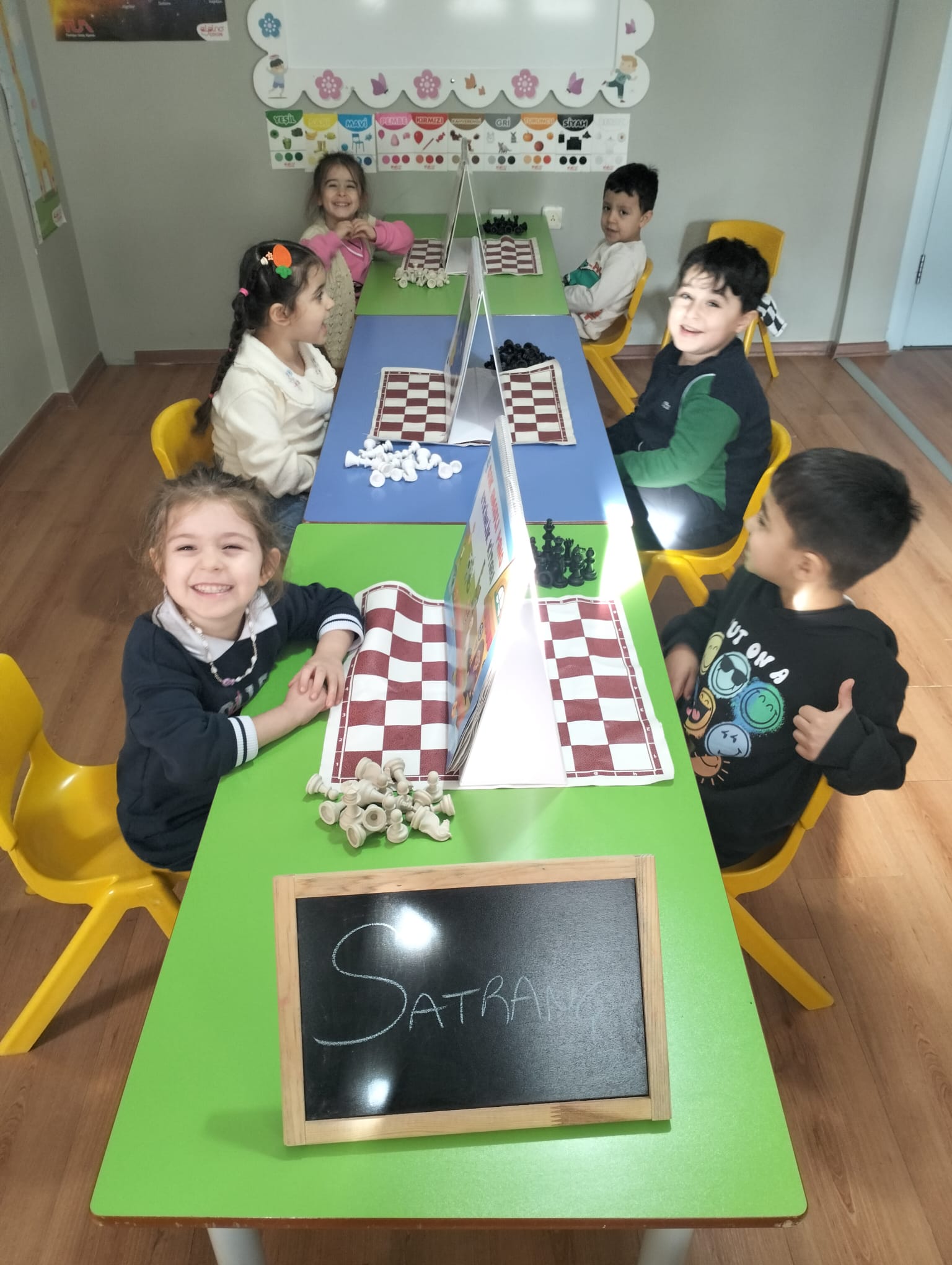 Satranç etkinliğinde keyifle vakit geçiren çocuklar