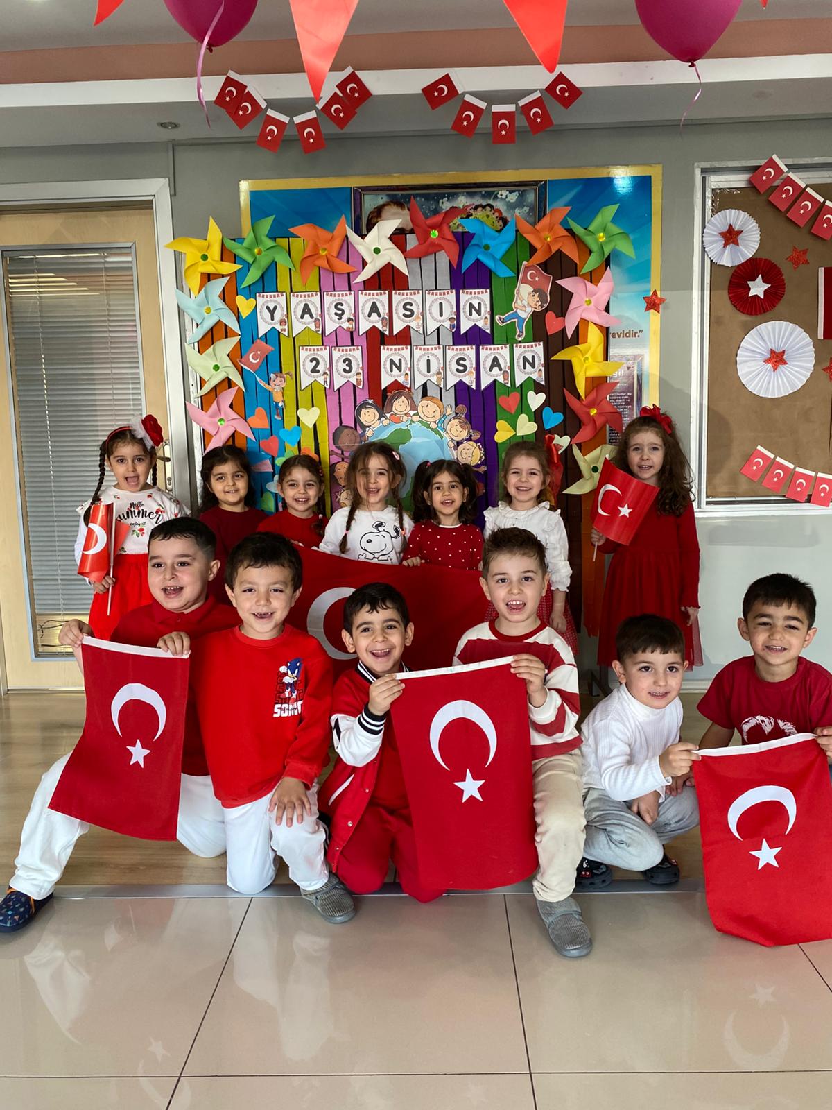 23 Nisan kutlamasında Türk bayraklarıyla poz veren çocuklar