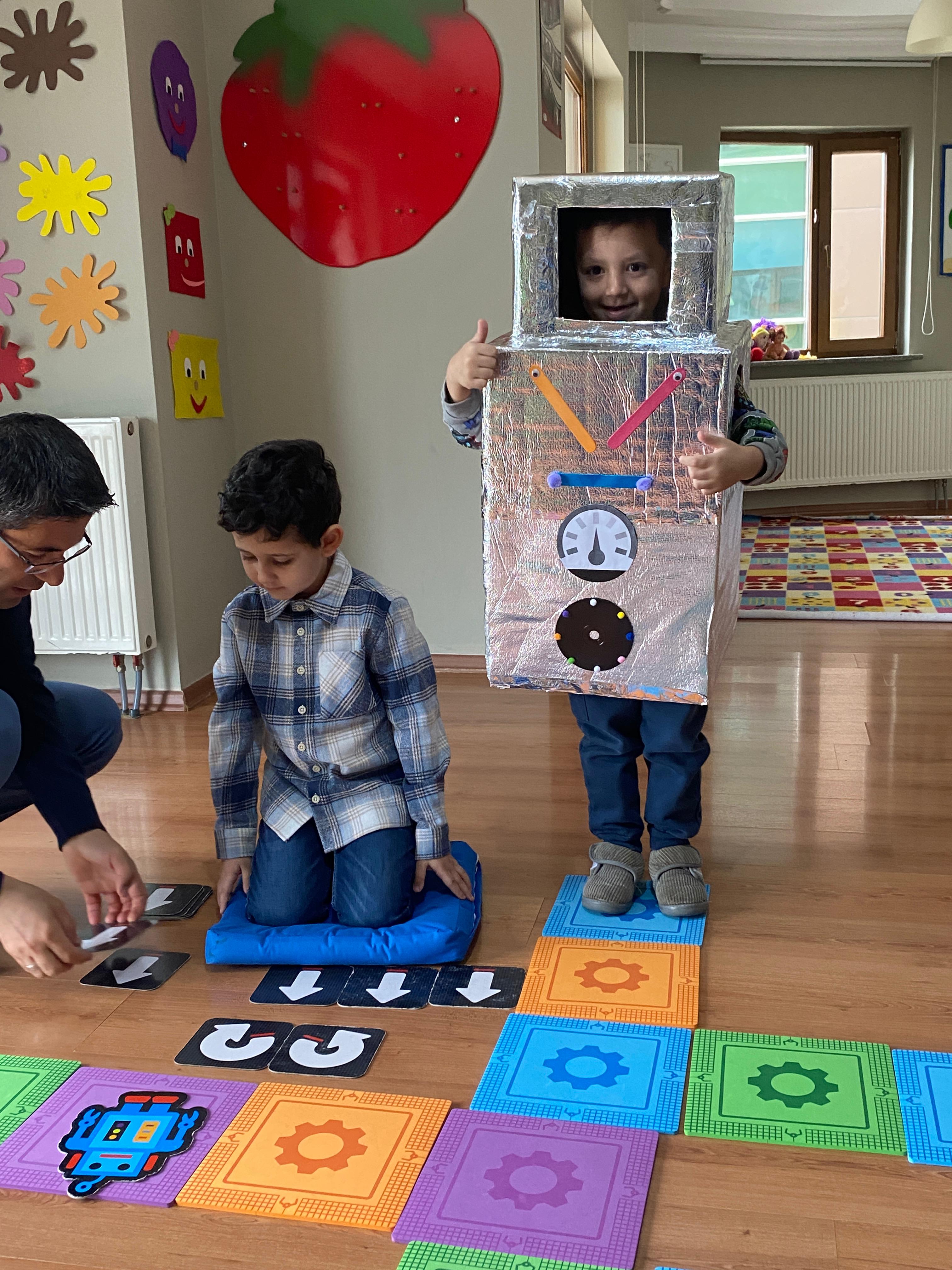 Robot kostümüyle kodlama parkurunda oynayan öğrenci